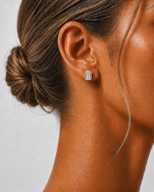 Emerald cut diamond bezel stud in yellow gold, worn on the ear