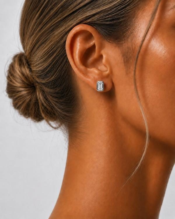 Emerald cut diamond bezel stud in white gold, worn on the ear