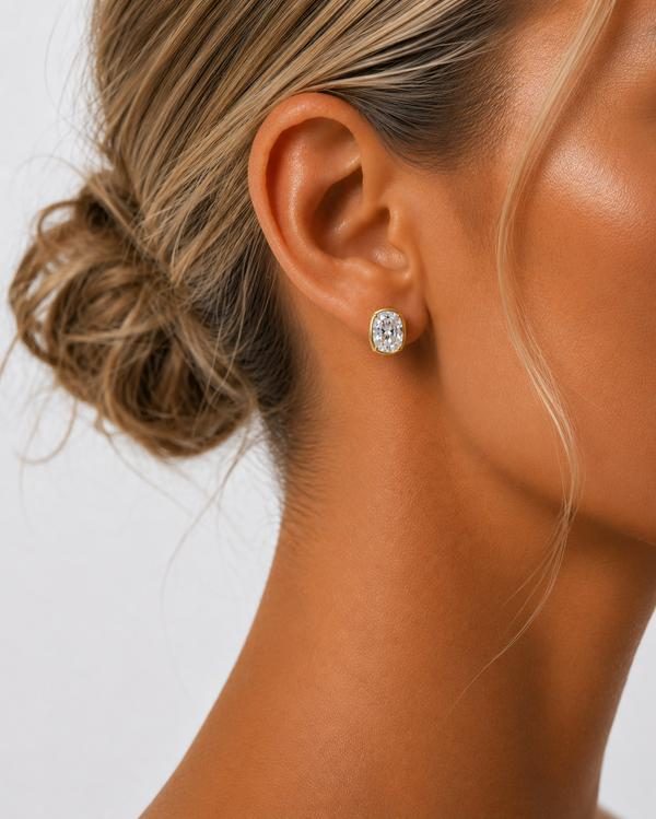 Cushion cut diamond bezel stud in yellow gold, worn on the ear