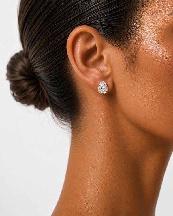 Pear diamond bezel stud in rose gold, worn on the ear