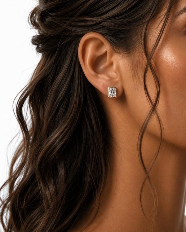 Radiant cut diamond bezel stud in rose gold, worn on the ear