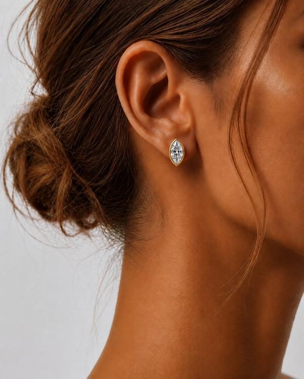 Marquise diamond bezel stud in yellow gold, worn on the ear